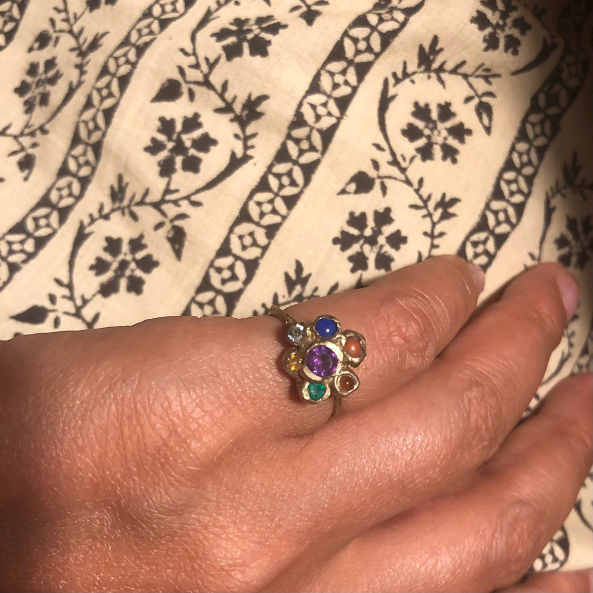 Anello Chakra MandalaT con sette pietre naturali colorate ispirato ai fiori del Callistemone indossato su un dito