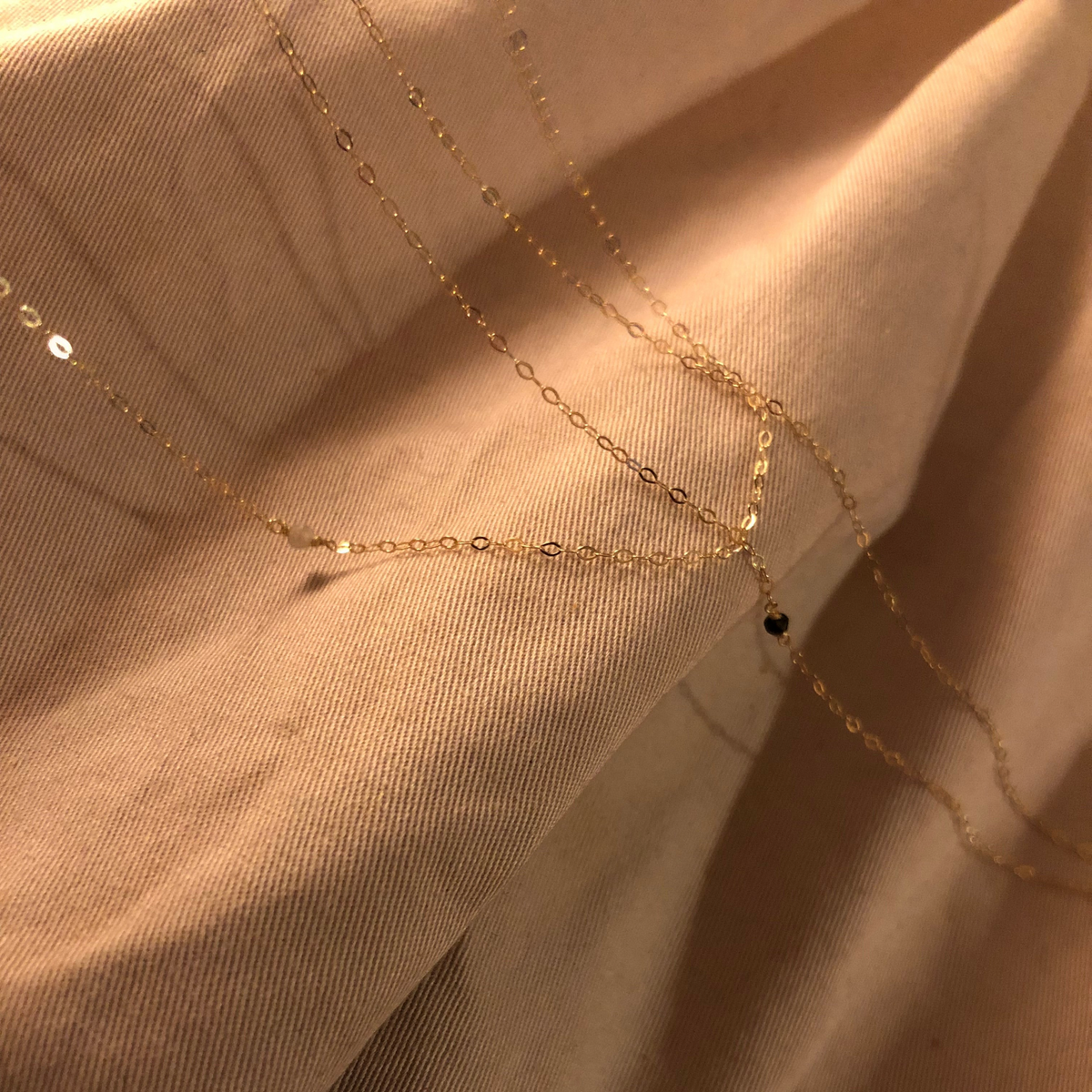 Set MandalaT composto da collana e braccialetto in oro sottile con piccoli diamanti naturali su tessuto beige