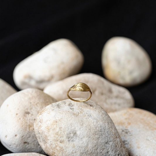 Anello Alloro MandalaT in oro con design a foglia artigianale poggiato su pietre naturali