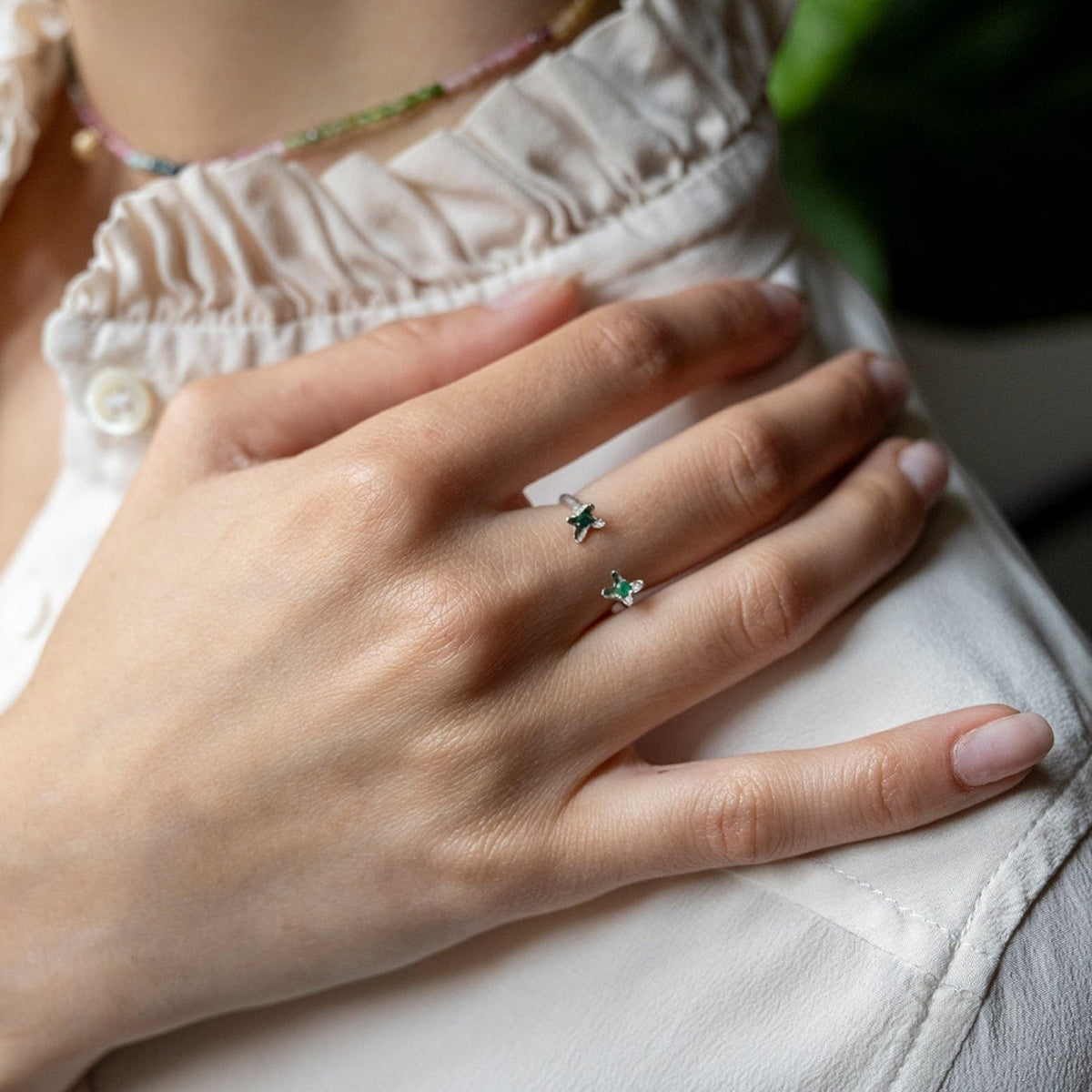 Anello aperto MandalaT Chiodi di garofano in argento con pietre verdi indossato su una mano