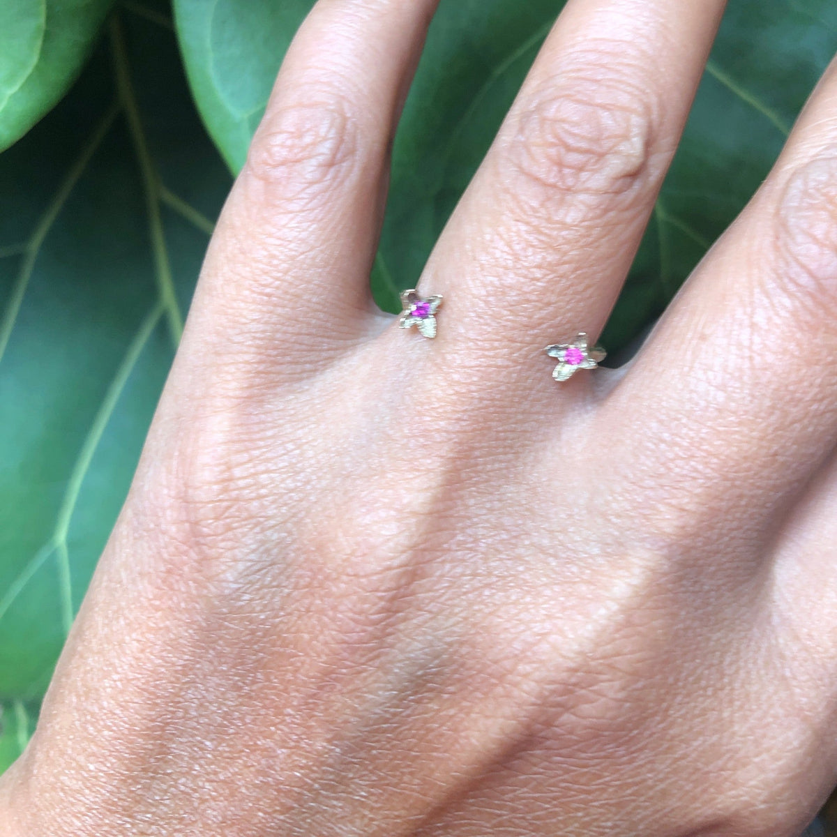 Anello aperto MandalaT Chiodi di garofano in metallo prezioso con piccole pietre rosa indossato su un dito