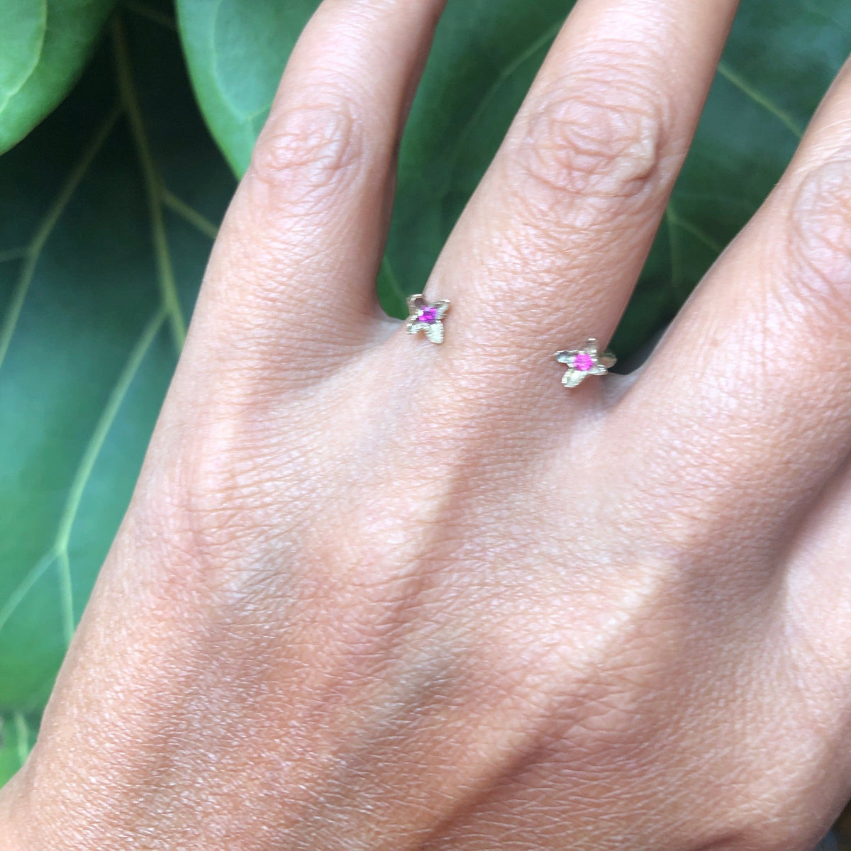 Anello aperto MandalaT Chiodi di garofano in metallo prezioso con piccole pietre rosa indossato su un dito