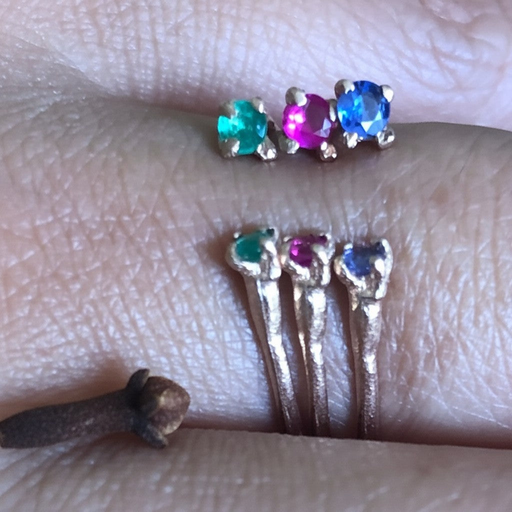 Anello aperto MandalaT Chiodi di garofano in oro con tre pietre preziose colorate indossato su un dito
