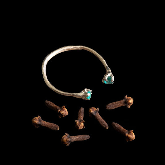 Anello aperto MandalaT in oro con smeraldi, design ispirato ai chiodi di garofano su sfondo nero