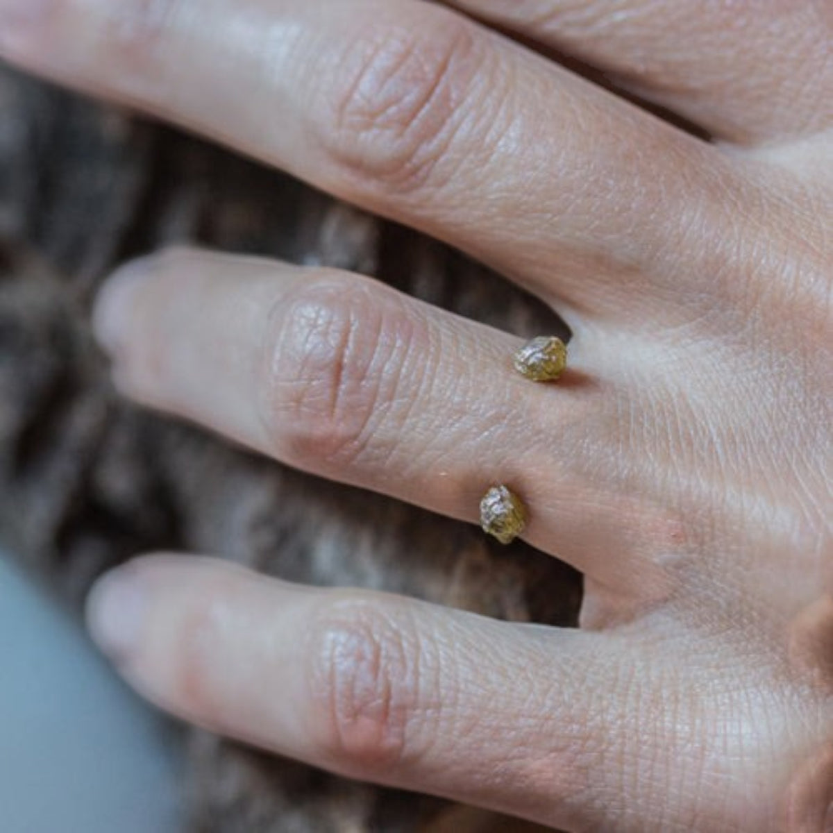 Anello aperto MandalaT con due grani di pepe dorati che ricordano piccoli pianeti indossato su un dito