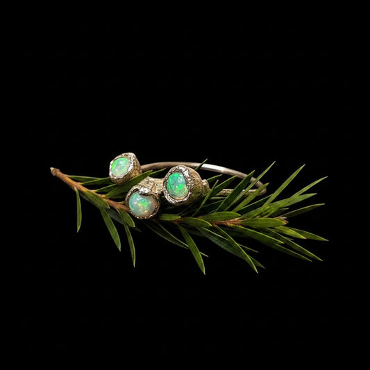 Anello MandalaT Calistemone in argento con tre pietre opali incastonate su un rametto di pino