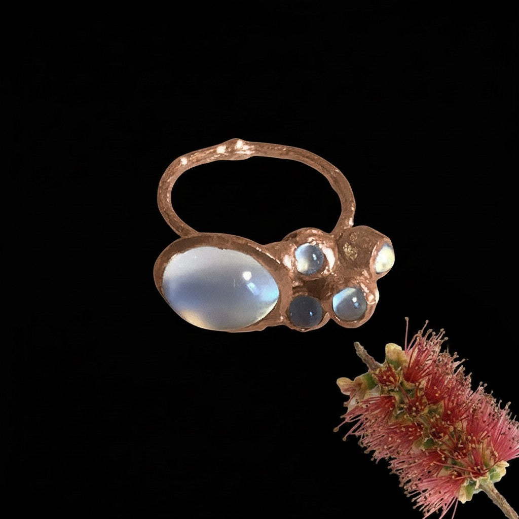 Anello MandalaT Callistemone a forma di ramo in metallo ramato con pietre di luna lucenti su sfondo nero
