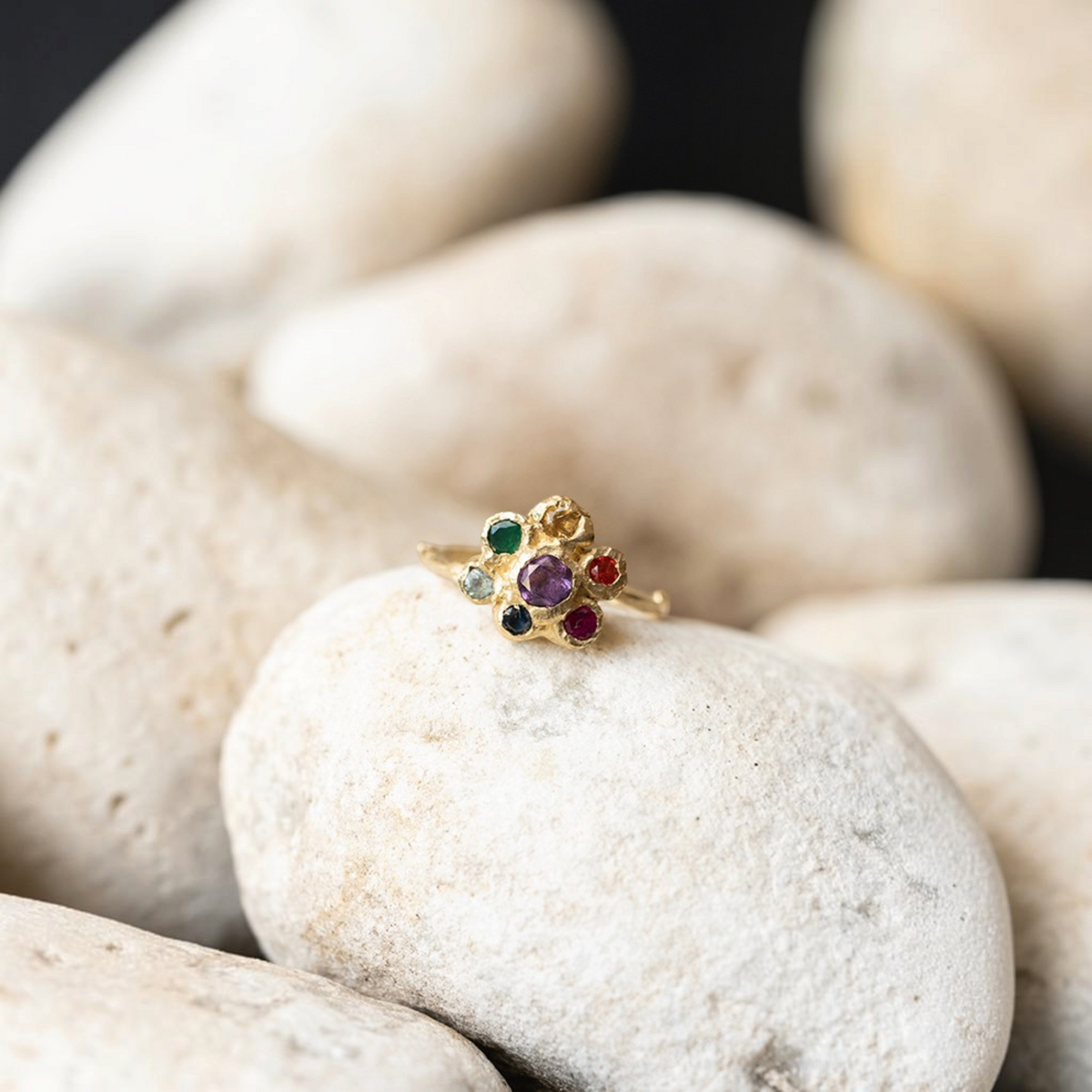 Anello Chakra MandalaT in oro con sette pietre preziose colorate ispirato ai fiori di Callistemone su pietra bianca