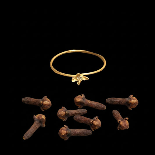 Anello solitario MandalaT in oro con pietra preziosa incastonata a forma di chiodo di garofano su sfondo nero