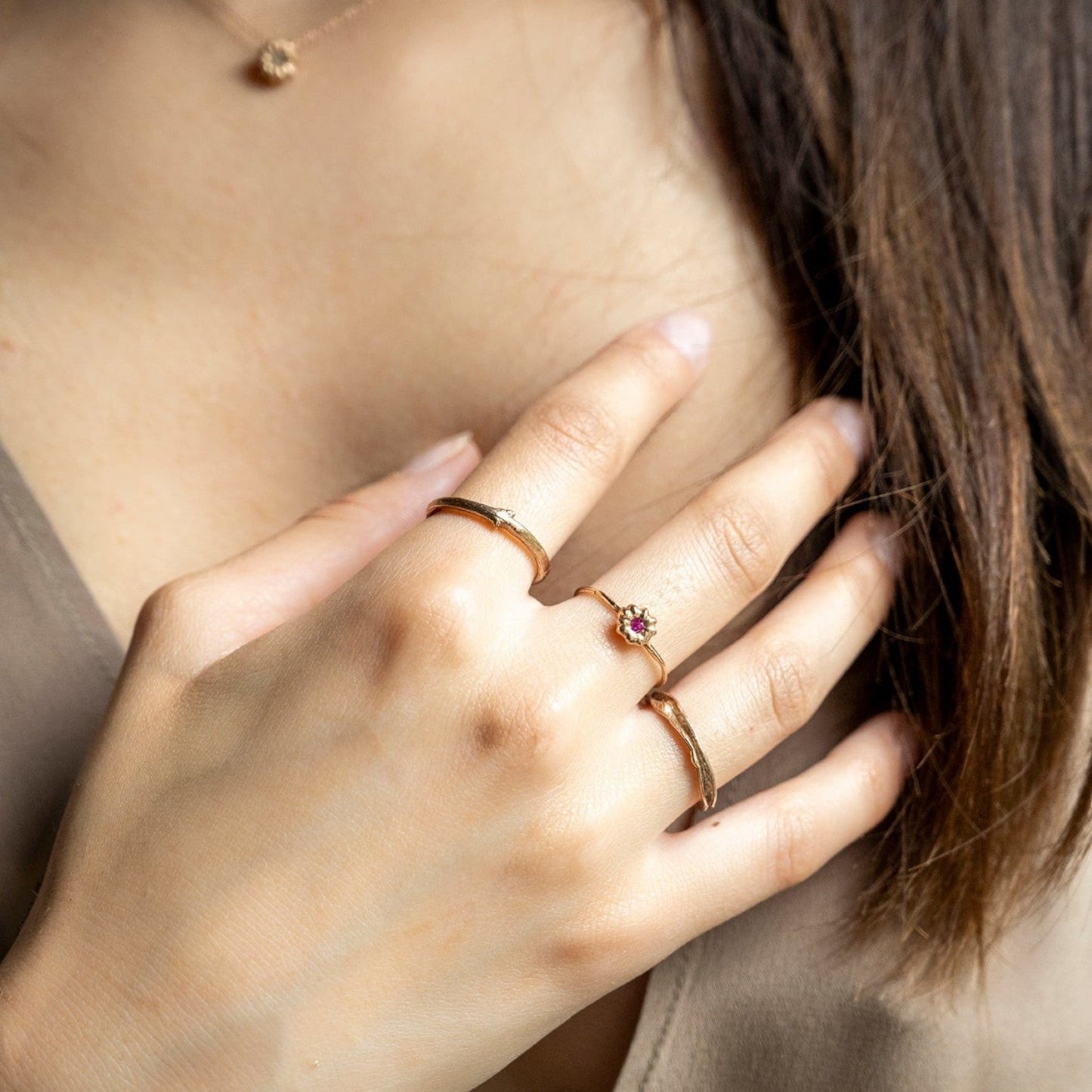 Anello MandalaT Phytolacca in oro rosa con piccolo rubino indossato su una mano femminile