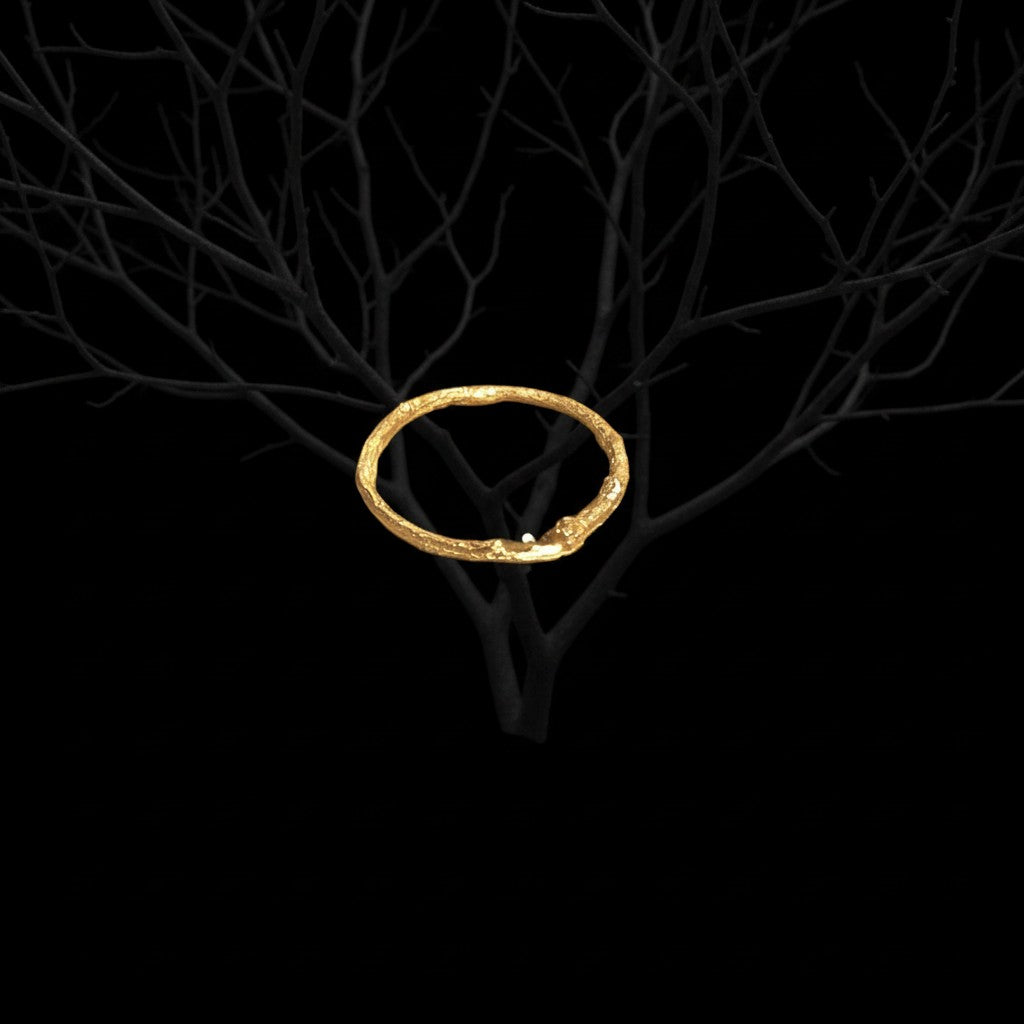 Anello MandalaT a forma di ramo dorato con texture naturale, avvolto su un ramo scuro su sfondo nero
