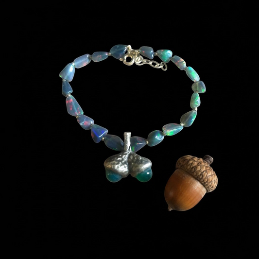 Bracciale MandalaT con ghiande in bronzo e pietre di opale scuro dai riflessi cangianti su sfondo nero