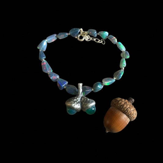 Bracciale MandalaT con ghiande in bronzo e pietre di opale scuro dai riflessi cangianti su sfondo nero