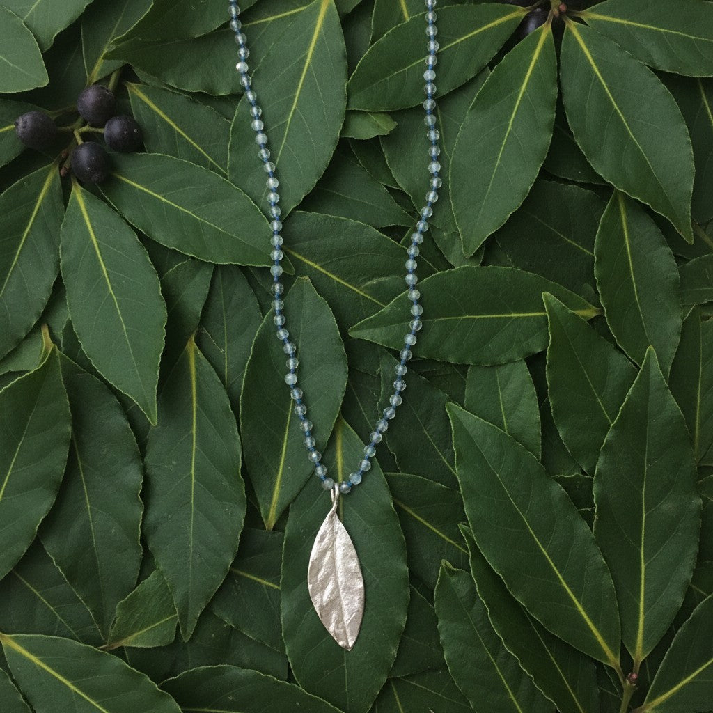 Collana MandalaT con ciondolo a forma di foglia di alloro in argento e catenina di Labradorite annodata su foglie verdi