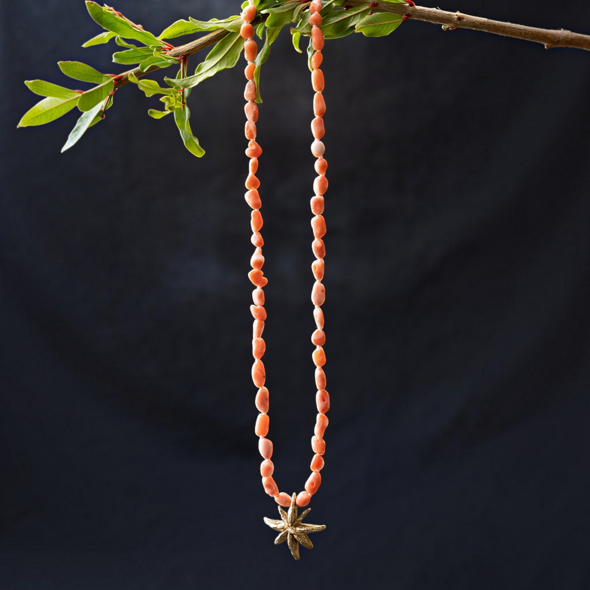 Collana MandalaT con pietre naturali color corallo e ciondolo artigianale a forma di anice stellato dorato