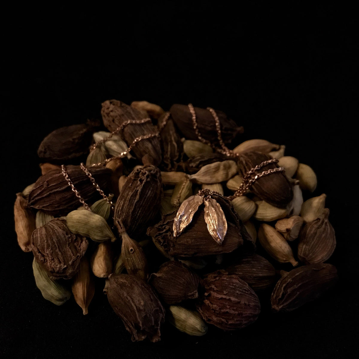 Collana MandalaT Cardamomo in oro rosa con ciondoli a forma di baccello di Cardamomo su letto di Cardamomo