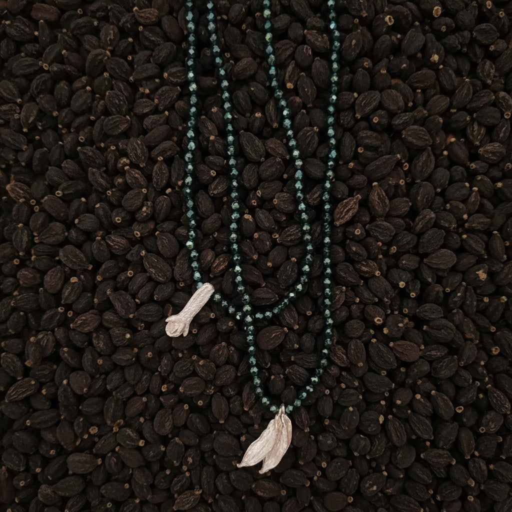 Collana MandalaT Cardamomo con Ematite sfaccettate verde e ciondoli a forma di baccello di Cardamomo in argento su letto di spezie