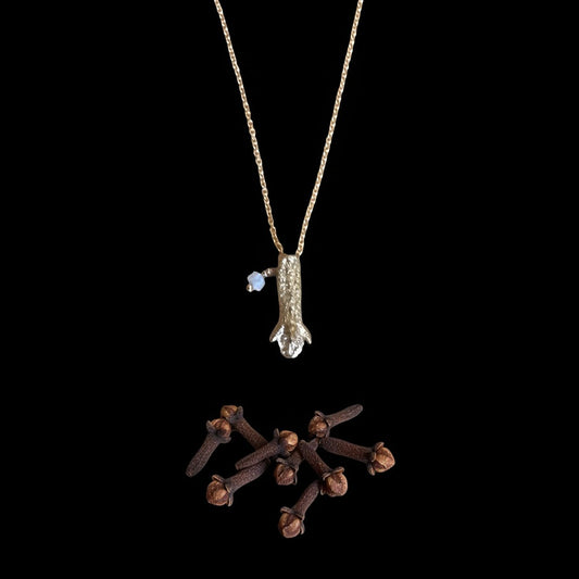 Collana MandalaT in oro con ciondolo a forma di chiodo di garofano e piccola pietra azzurra su sfondo nero