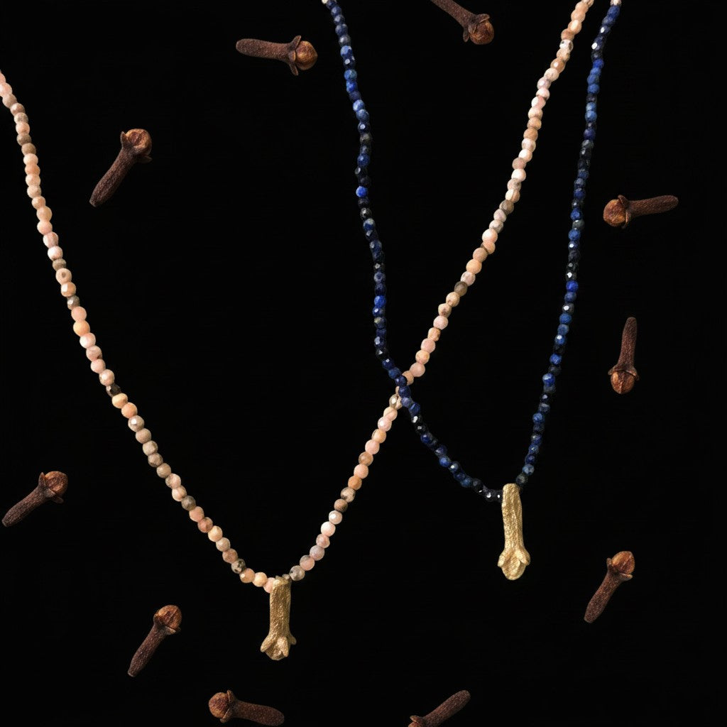 Collana MandalaT Chiodo di Garofano con perline in pietra naturale e ciondolo dorato su sfondo nero con chiodi di garofano