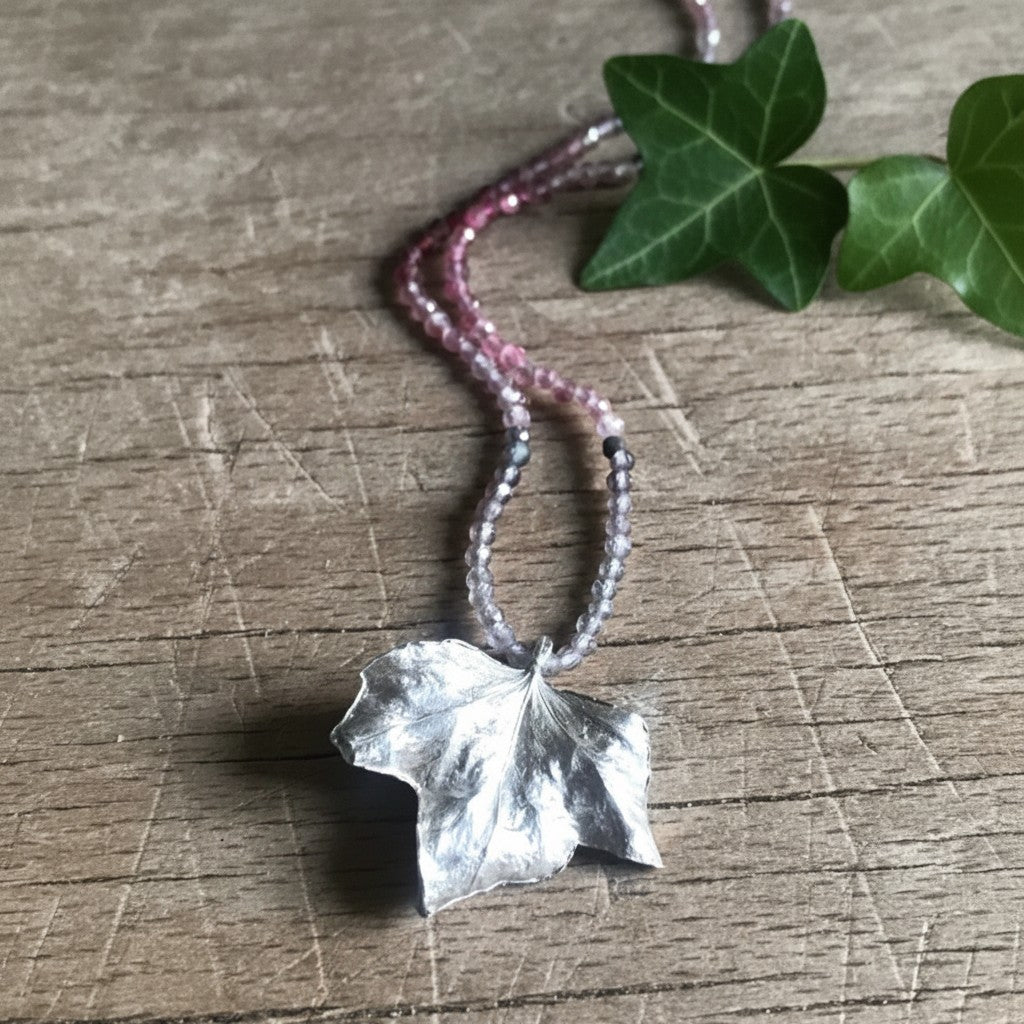 Collana Edera MandalaT con ciondolo a forma di foglia in argento e catenina di perline di zirconi sfumate rosa e grigie