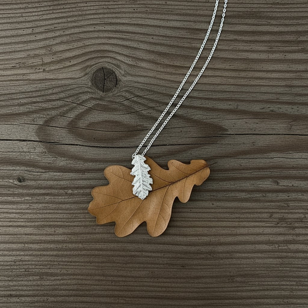 Collana MandalaT con ciondolo a forma di foglia di quercia in argento su una foglia secca naturale