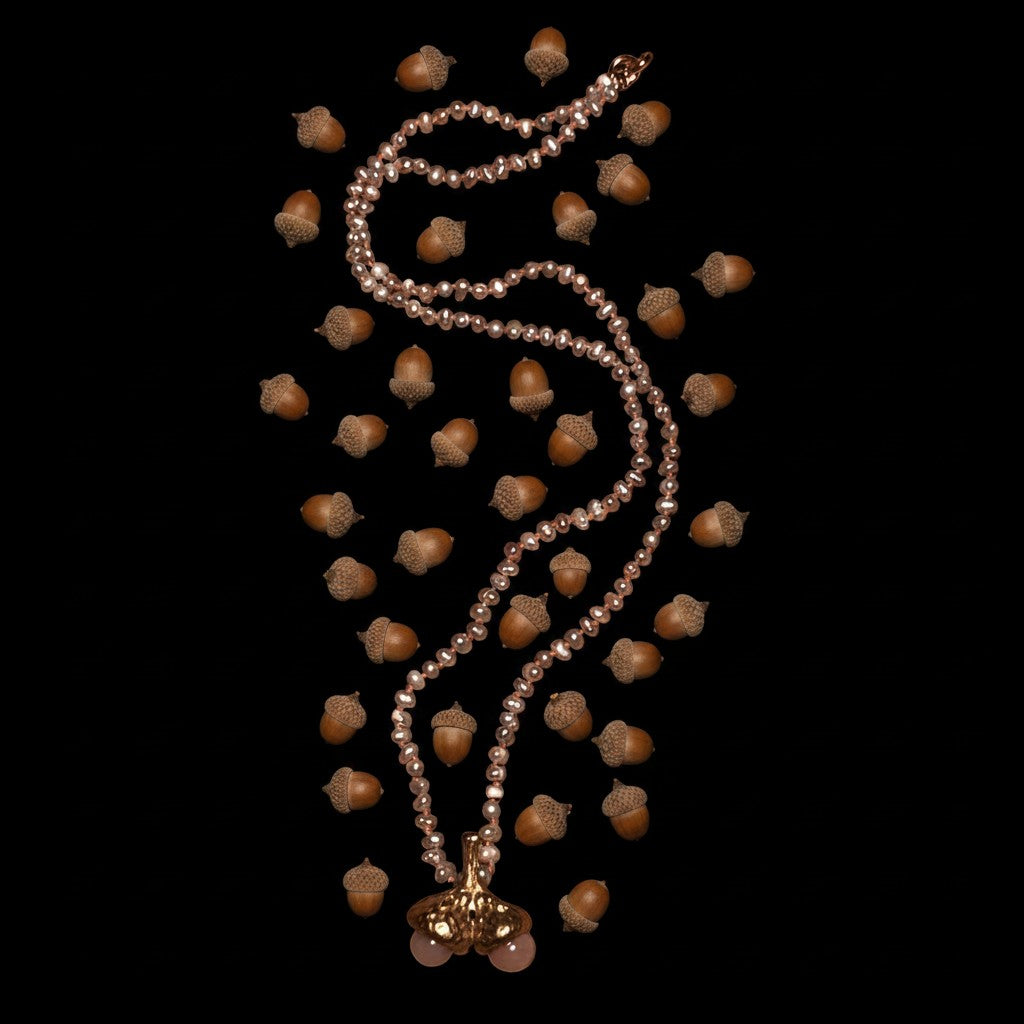 Collana MandalaT con perle grigie e nodi color rosa salmone e ciondolo a forma di due ghiande gemelle decorate con opali rosa su sfondo nero