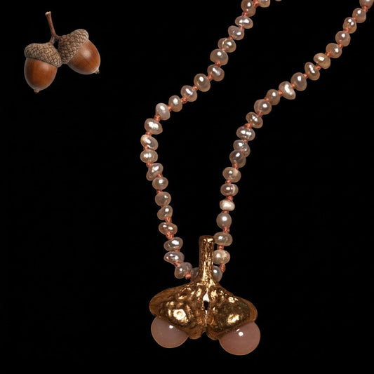 Collana MandalaT con ciondolo a forma di due ghiande rosate e perle grigie con nodi color albicocca su sfondo nero
