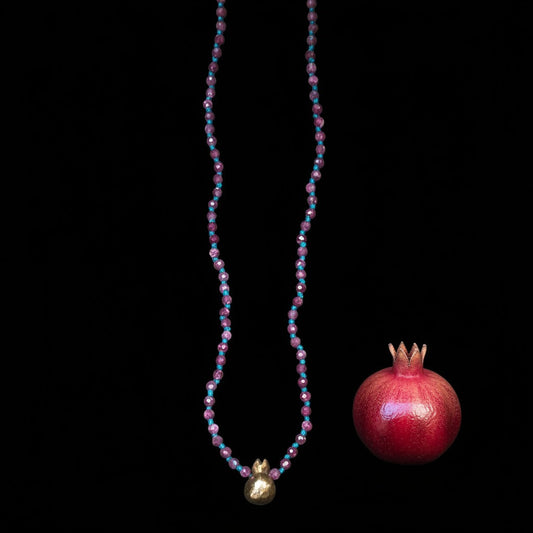 Collana MandalaT con radice di rubino e nodi verdi e ciondolo a forma di melograno su sfondo nero