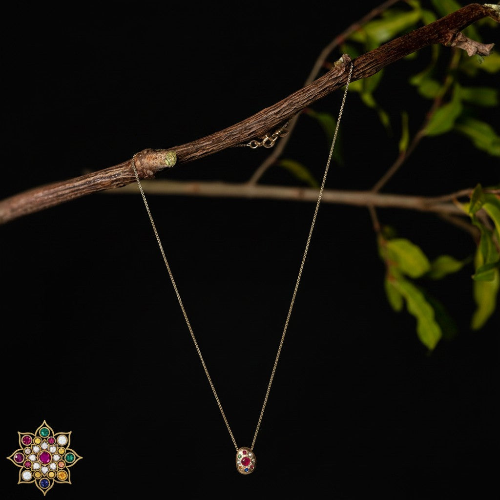 Collana MandalaT Navaratna in oro con nove pietre preziose incastonate in un ciondolo ovale su sfondo nero