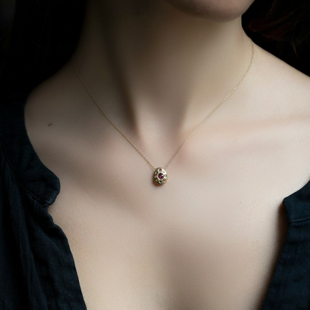 Collana MandalaT Navaratna in oro con nove pietre preziose incastonate in un ciondolo circolare indossata al collo