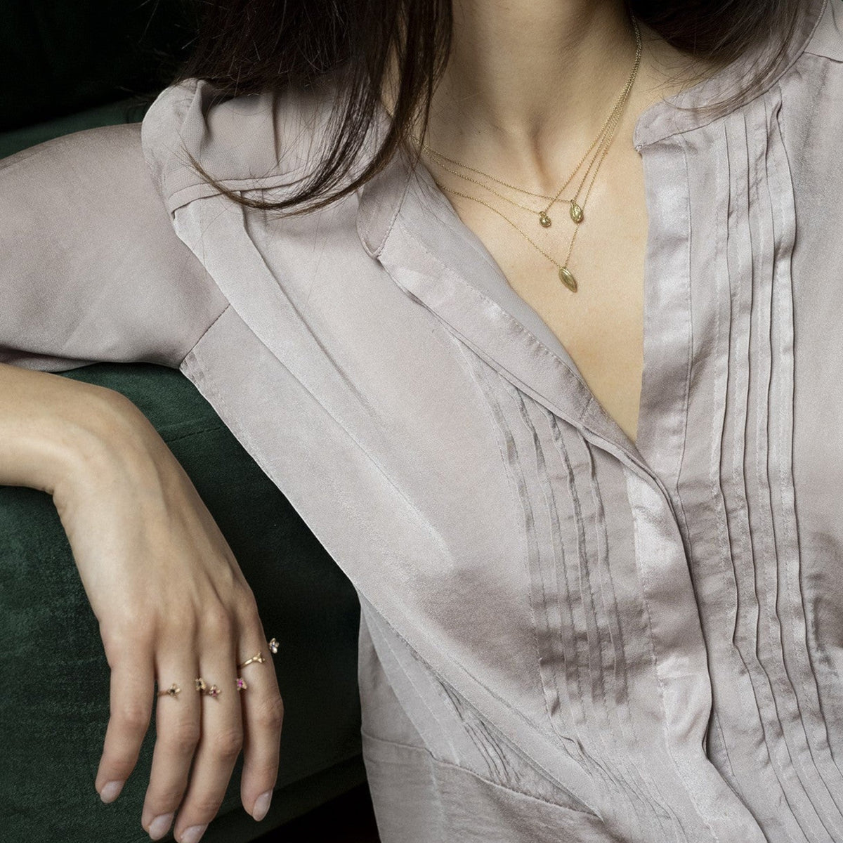 Collana Pepe MandalaT in oro con piccoli ciondoli a forma di chicco, indossata su una camicetta di seta color tortora