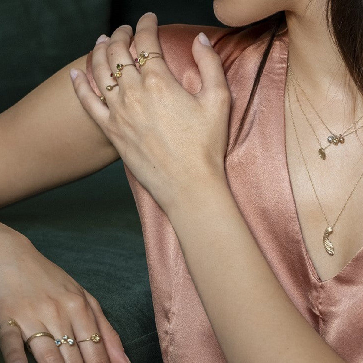 Collana Pepe MandalaT in oro con pietre colorate indossata da una donna con top in seta rosa