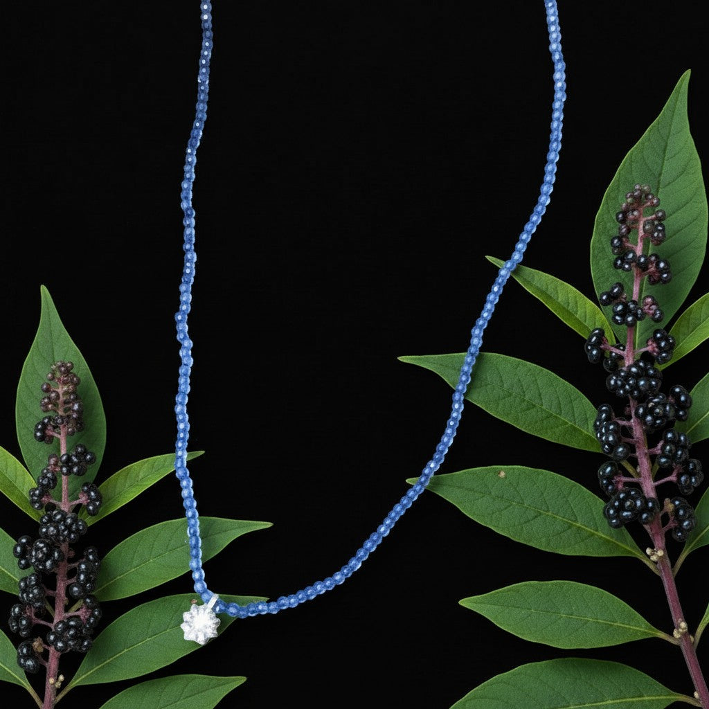 Collana MandalaT Phytolacca con catenina di perline azzurre e ciondolo a forma di fiore su sfondo nero