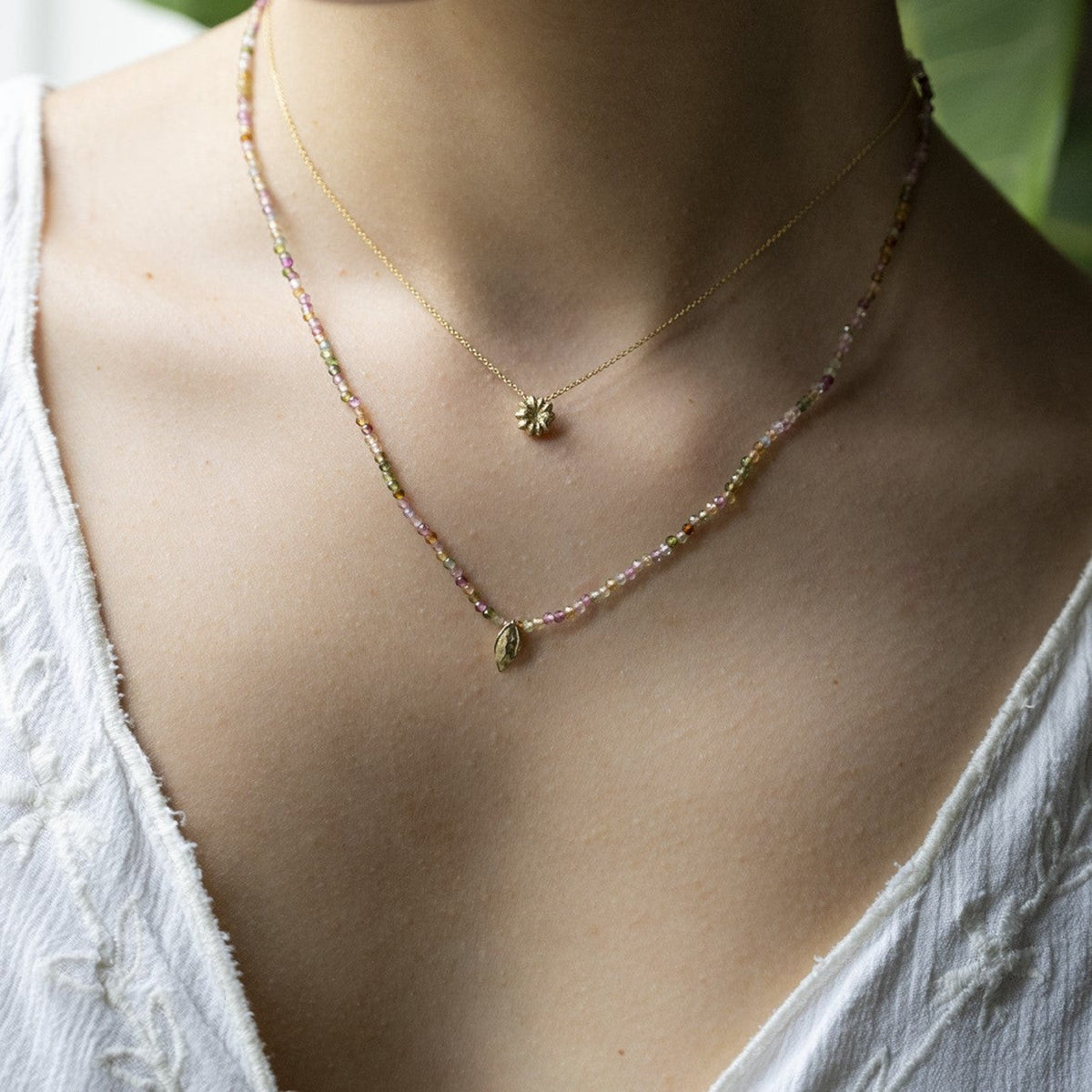 Collana MandalaT Phytolacca con ciondolo a forma di frutto di phytolacca in oro e catenina di perline multicolore con seme di mela indossata