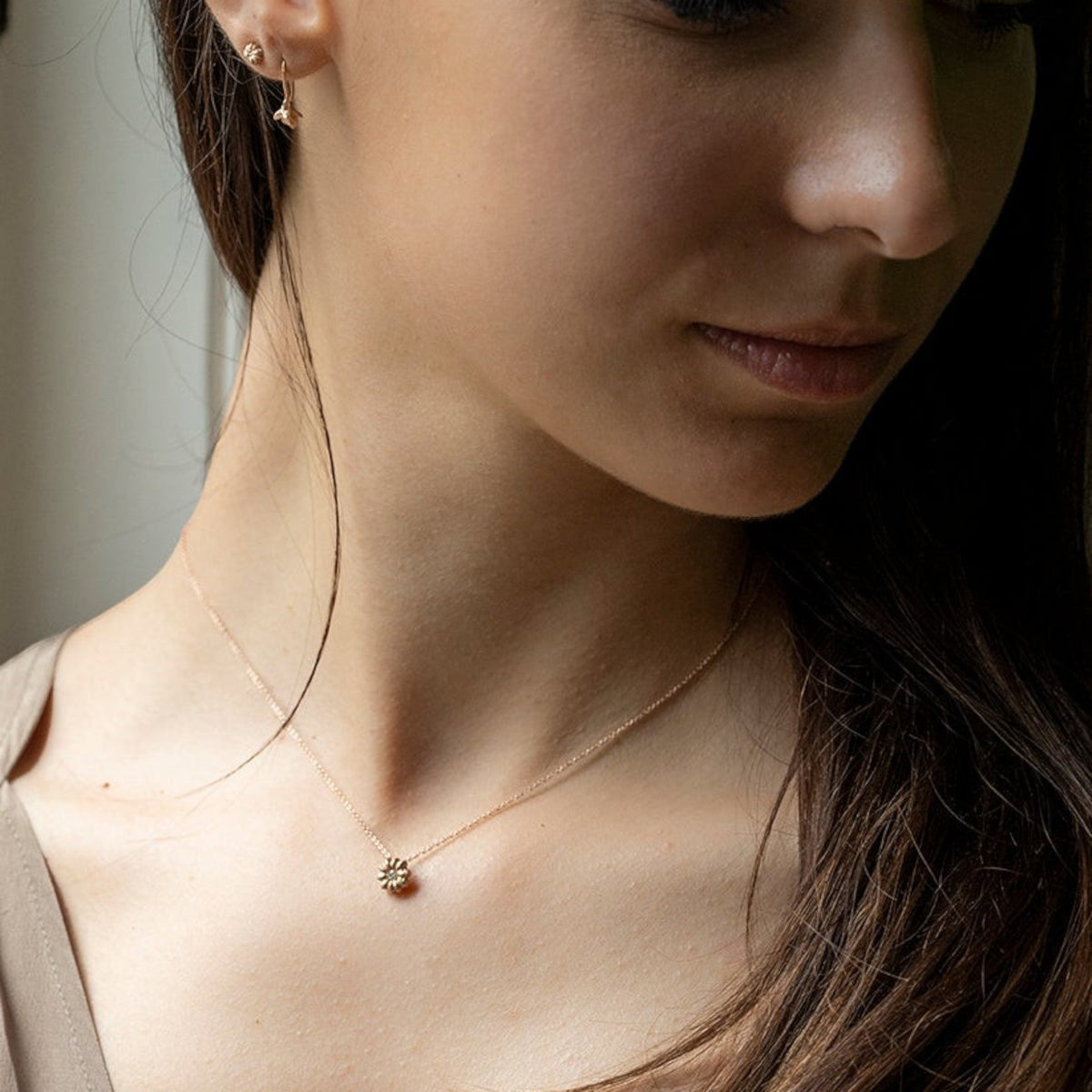 Collana MandalaT Phytolacca in oro con ciondolo a forma di fiore indossata da una modella