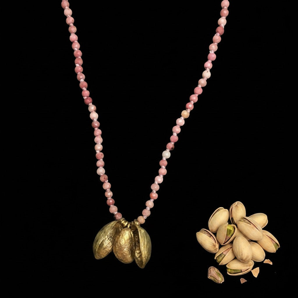 Collana MandalaT Pistacchio con Tormaline rosa annodati e ciondoli a forma di gusci e frutto del pistacchio dorato su sfondo nero