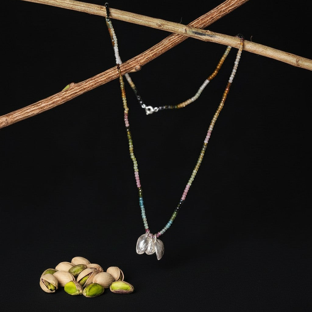 Collana MandalaT Pistacchio con pietre semipreziose multicolore e ciondolo a forma di guscio su sfondo nero