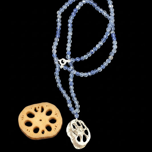 Collana MandalaT con ciondolo radice di loto in argento e catena di piccole pietre dure azzurre su sfondo nero