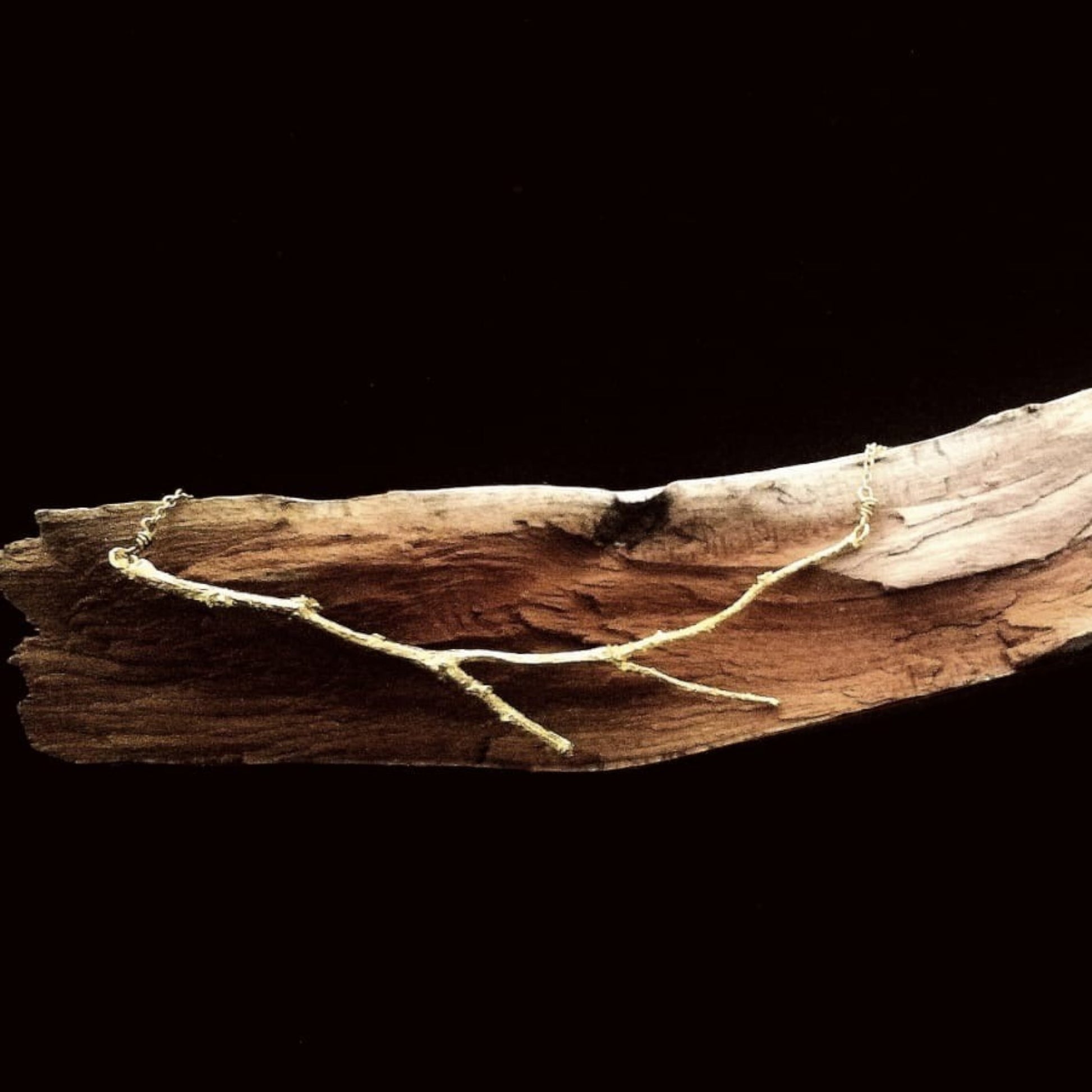 Girocollo MandalaT Ramo traverso in metallo dorato con design a rametto sottile su base di legno naturale