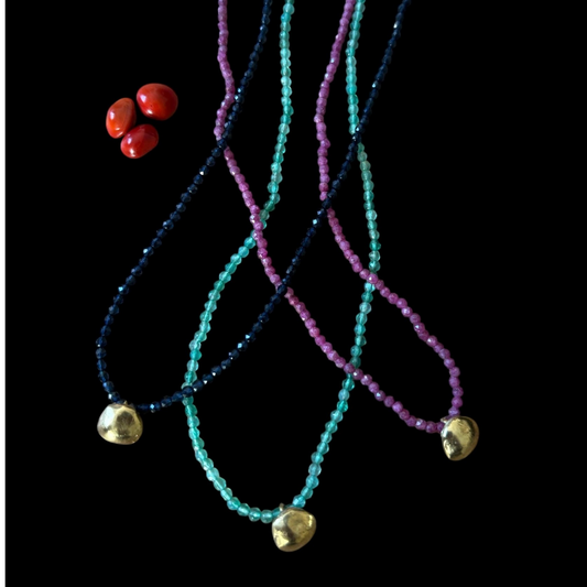 Collana Ratan gunj MandalaT con semi naturali, perline colorate e ciondolo dorato su sfondo nero