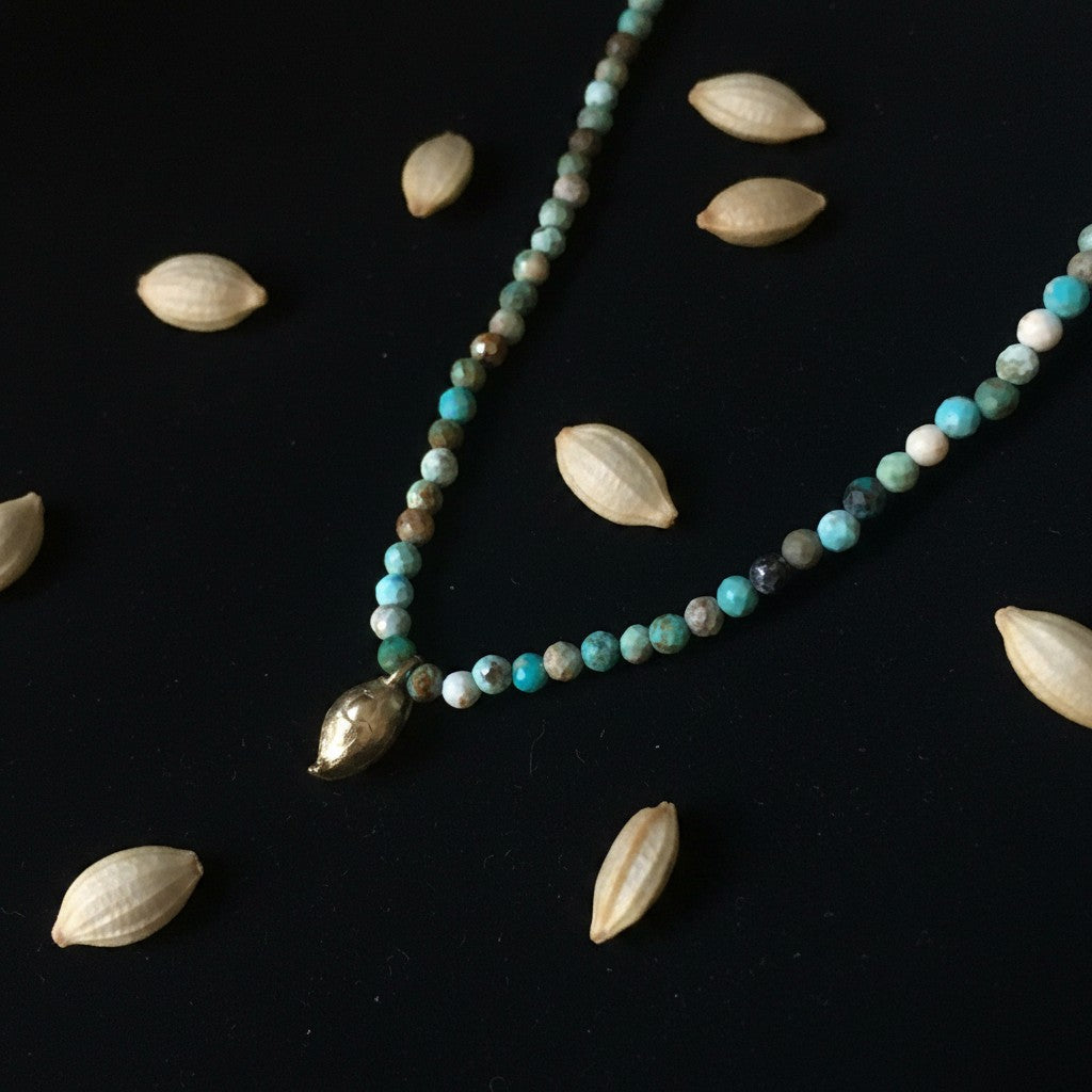 Collana MandalaT con ciondolo a forma di seme di limone in bronzo e perline di turchese su sfondo nero