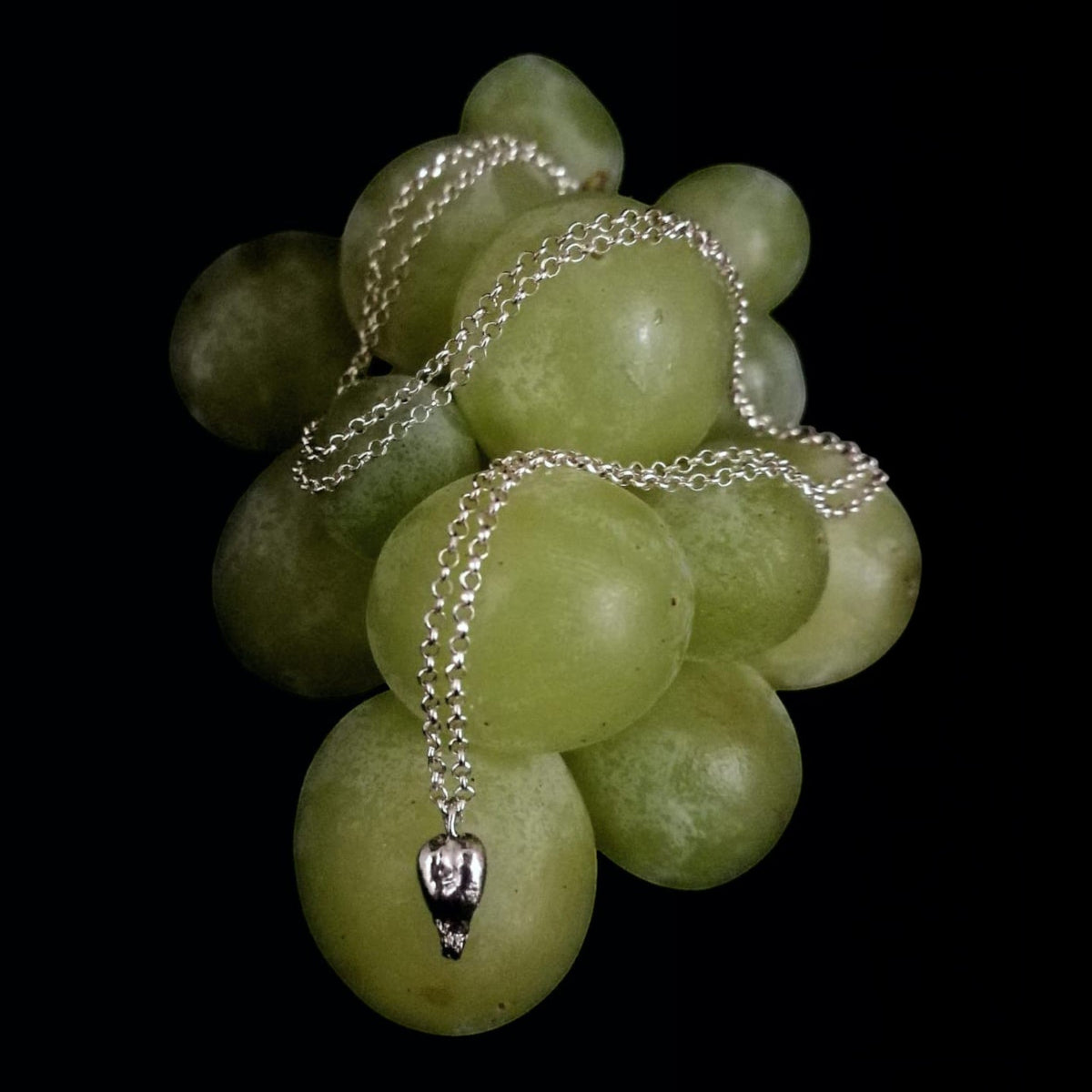 Collana MandalaT in argento con ciondolo a forma di seme d'uva, simbolo di salute e benessere, su grappolo d'uva