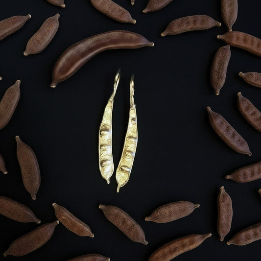 Orecchini pendenti MandalaT Carruba in metallo dorato con texture organica ispirata ai baccelli di carruba