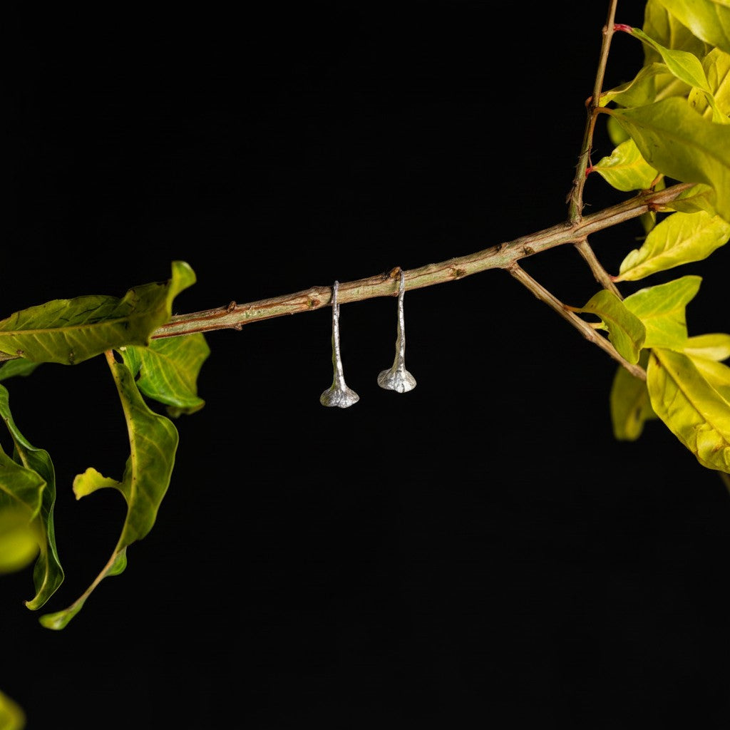 Orecchini MandalaT Dente di Leone in argento con design scultoreo a forma di trombetta appesi a un ramo