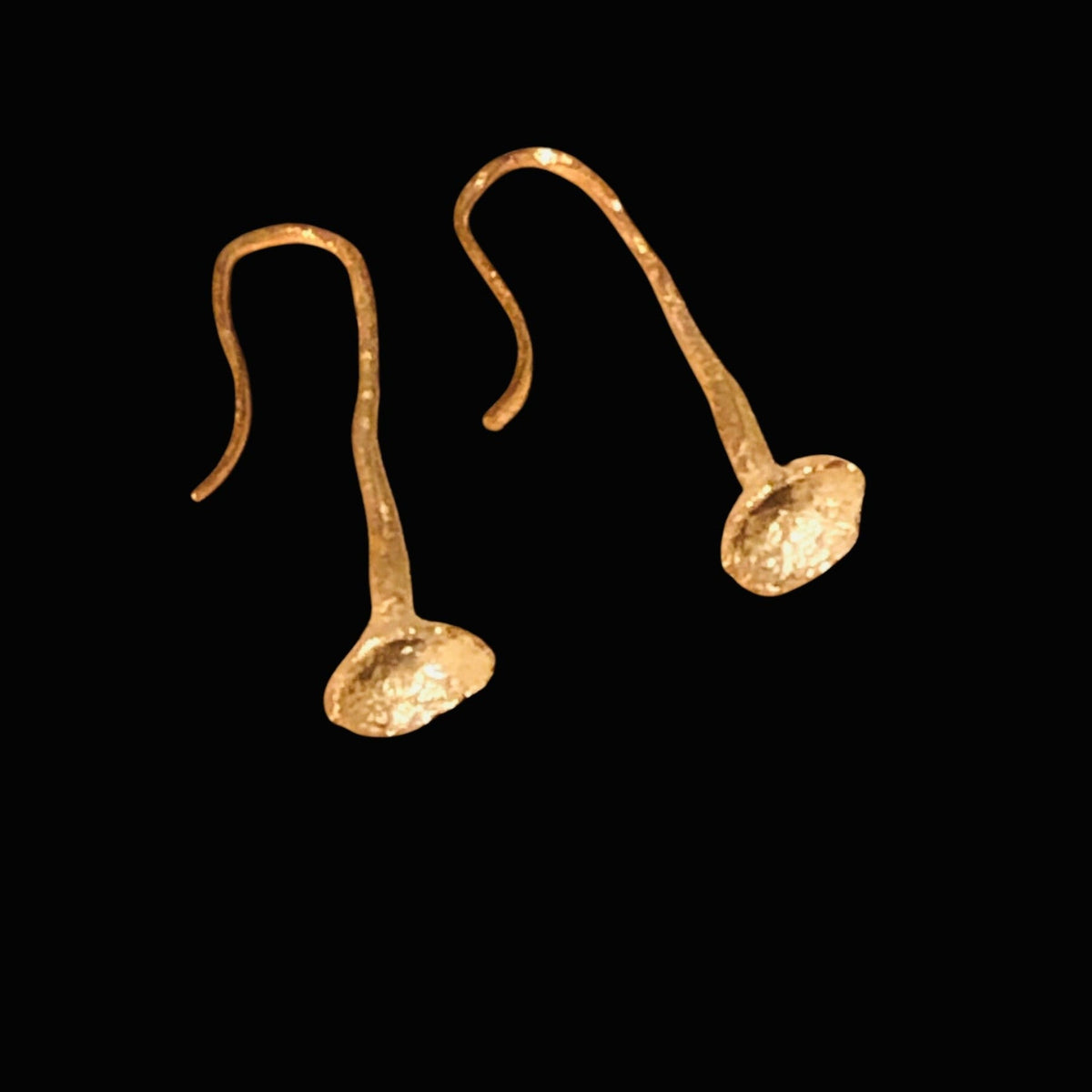 Orecchini MandalaT Dente di Leone in oro con design scultoreo a forma di trombetta su sfondo nero