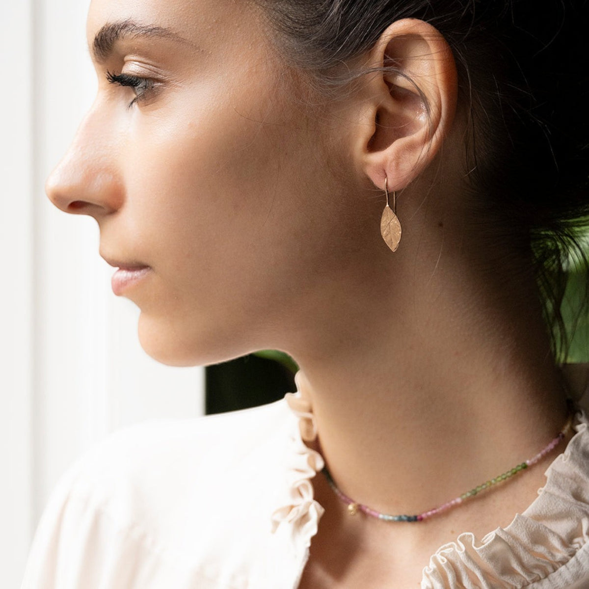 Orecchini MandalaT a forma di foglia di alloro in oro rosa, ideali come regalo di laurea, indossati da una modella