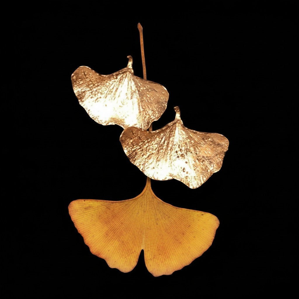 Orecchini MandalaT a forma di foglia di Gingko in metallo dorato con finitura lucida su sfondo nero