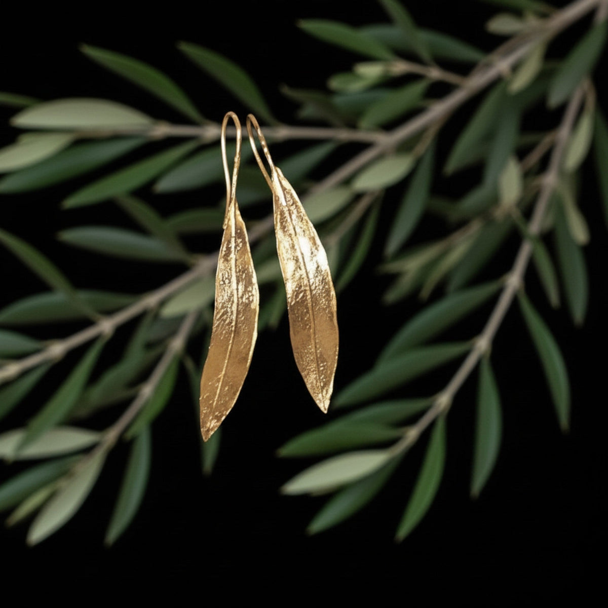 Orecchini MandalaT a forma di foglia d'ulivo dorata, lunghi 5,5 cm, dal design artigianale ed elegante.