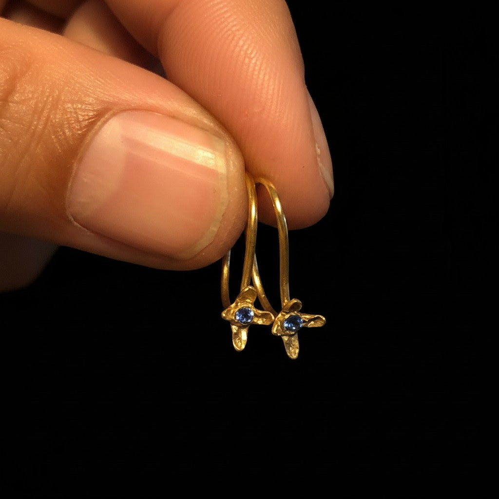 Orecchini ad amo MandalaT a forma di chiodo di garofano in oro con piccola pietra preziosa blu incastonata