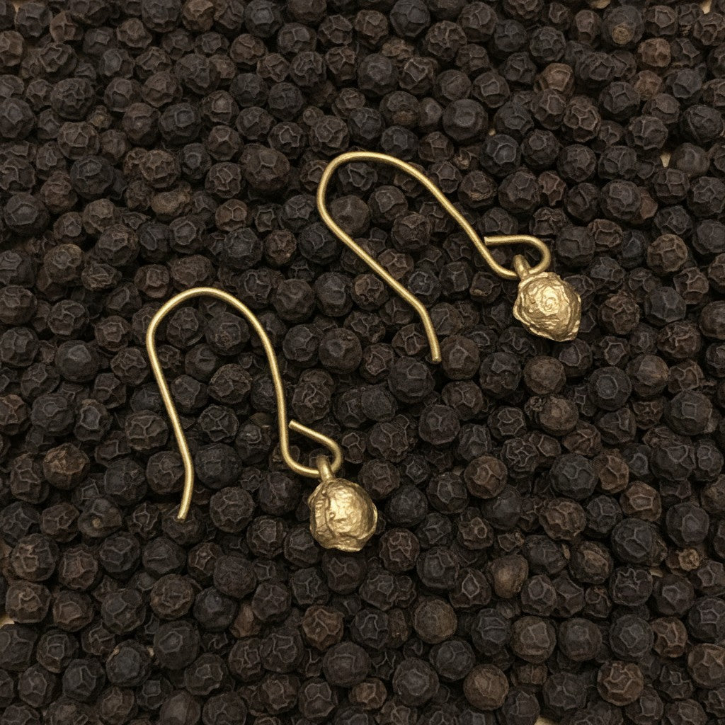 Orecchini MandalaT a forma di chicco di pepe in bronzo su letto di grani di pepe nero